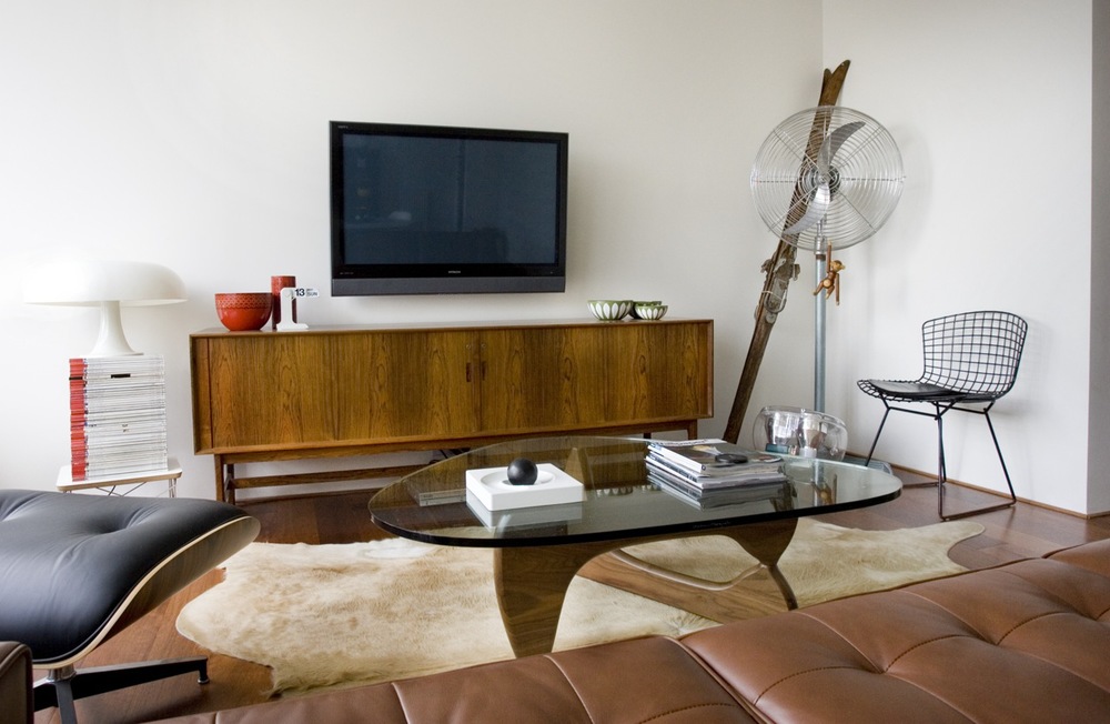 SALA COM RACK EM MADEIRA, SOFÁ EM COURO E MESA DE CENTRO COM TAMPO DE VIDRO